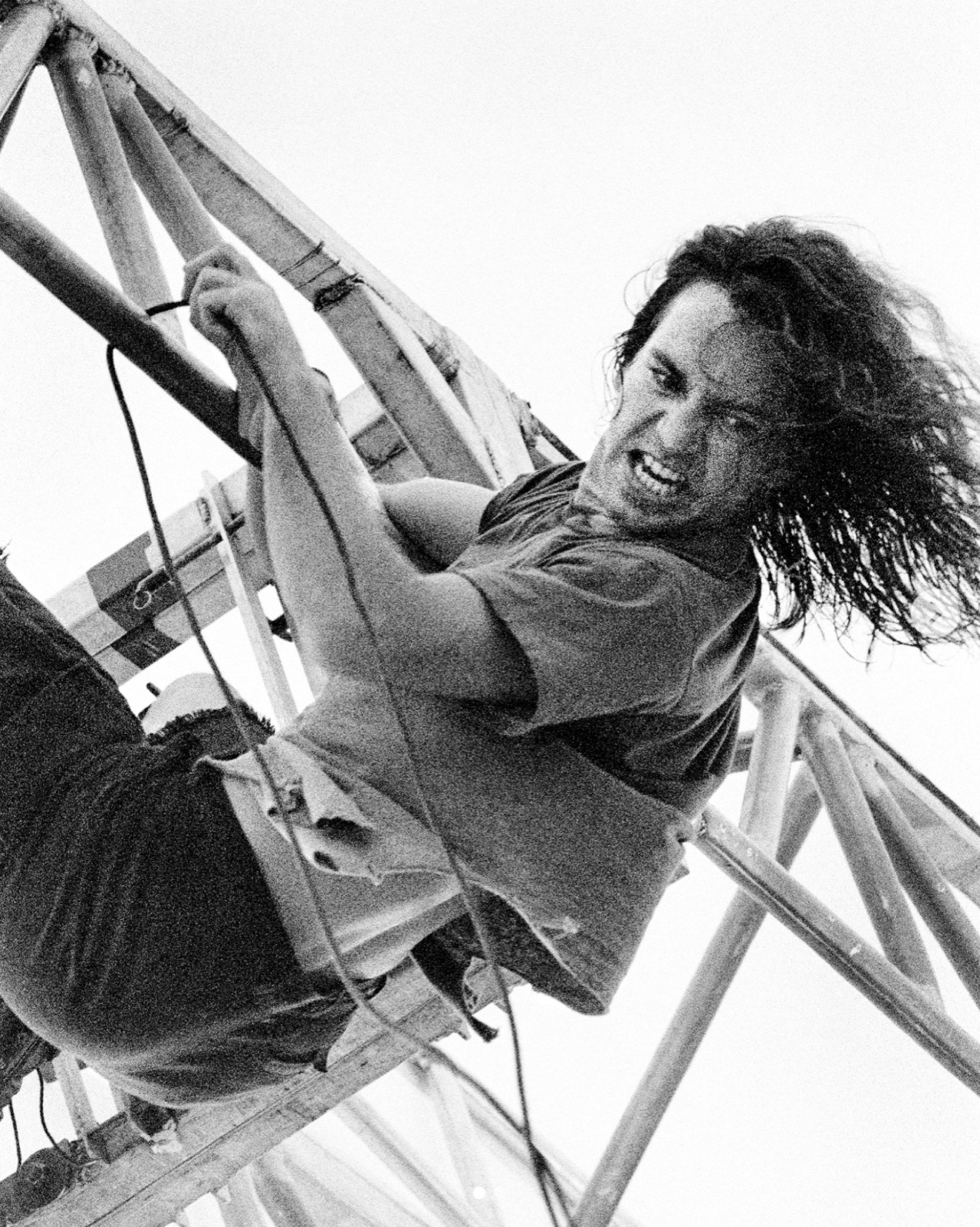 Eddie Vedder of Pearl Jam, climbing the stage truss at Pinkpop Festival, 1992.